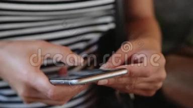 关闭女孩使用智能手机在咖啡馆户外短信手机。 手拿手机..